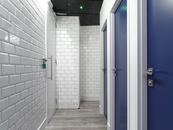 Refurbished school toilets with tiled walls and blue doors
